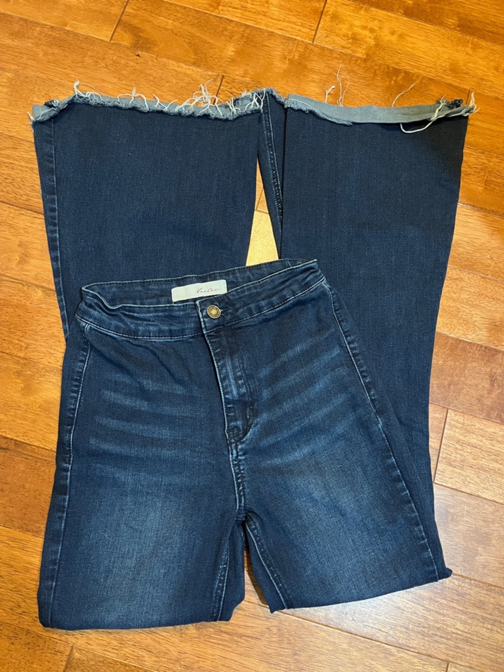 KanCan high-rise flare jeans in a dark wash featuring a raw, frayed hem. 3/25